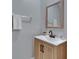 Well-lit powder room with a modern vanity, sink, and a stylish framed mirror at 15718 Fort Island Pl, Sun City Center, FL 33573