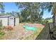 Spacious backyard featuring green grass, shed, and trees, offering a serene outdoor space at 16169 Gardendale Dr, Tampa, FL 33624