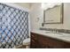 Bathroom featuring marble countertop vanity, white toilet, and a blue pattern shower curtain at 16169 Gardendale Dr, Tampa, FL 33624
