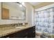 Bathroom featuring granite countertop vanity, toilet, and a vintage shower curtain at 16169 Gardendale Dr, Tampa, FL 33624