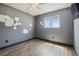 Bedroom with gray walls, wood-look flooring, and a window providing natural light at 16169 Gardendale Dr, Tampa, FL 33624