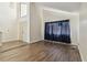 Bright living room with wood floors, closet, and large window with blue curtains for natural light at 16169 Gardendale Dr, Tampa, FL 33624