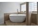 Bathroom featuring a standalone tub, glass block window, and walk-in tiled shower at 1695 Pinellas Bayway S # E6, St Petersburg, FL 33715