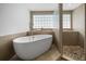A modern bathroom featuring a standalone tub, glass block window, and tiled shower at 1695 Pinellas Bayway S # E6, St Petersburg, FL 33715