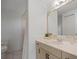 Bathroom vanity featuring a granite countertop, framed mirror, wood cabinets, and a decorative faucet at 1695 Pinellas Bayway S # E6, St Petersburg, FL 33715