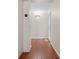 Neutral condo hallway featuring wood floors, white walls, and an inviting entrance door at 1695 Pinellas Bayway S # E6, St Petersburg, FL 33715