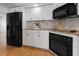 Kitchen with black appliances, light countertops, and ample storage in the white cabinets at 1695 Pinellas Bayway S # E6, St Petersburg, FL 33715