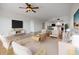 A neutral living area with ample seating, wood floors and a view into the kitchen at 1695 Pinellas Bayway S # E6, St Petersburg, FL 33715