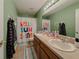 Well-lit bathroom with double sinks and a cheerful 'Hello Sunshine' shower curtain at 18345 Fish Loop, Land O Lakes, FL 34638
