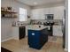 Bright kitchen featuring white cabinets, stainless steel appliances, and a contrasting blue island at 18345 Fish Loop, Land O Lakes, FL 34638