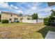 Spacious backyard with a white fence, lush greenery, and neighbor's home in the background at 18837 Litzau Ln, Land O Lakes, FL 34638