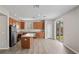 Open-concept kitchen with a center island, wood cabinetry, stainless appliances, and wood-look floors at 18837 Litzau Ln, Land O Lakes, FL 34638