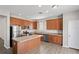 Well-lit kitchen boasts wood cabinets, stainless steel appliances, an island, and wood-look flooring at 18837 Litzau Ln, Land O Lakes, FL 34638