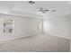 Spacious main bedroom with tray ceiling, fan, and neutral carpet at 18837 Litzau Ln, Land O Lakes, FL 34638