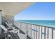 Balcony with white Adirondack chairs overlooking the ocean at 19418 Gulf Blvd # 507, Indian Shores, FL 33785