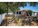 Fenced backyard featuring mature trees, a swing set, and a screened-in patio at 19610 Sunset Bay Dr, Land O Lakes, FL 34638