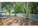 Spacious backyard with lush trees, white fencing, and a swing set for outdoor enjoyment at 19610 Sunset Bay Dr, Land O Lakes, FL 34638
