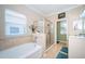 Bright bathroom featuring a soaking tub, glass enclosed shower, and a neutral color palette at 19610 Sunset Bay Dr, Land O Lakes, FL 34638