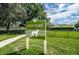 Dog park sign in a fenced grassy area, indicating a pet-friendly community amenity at 19610 Sunset Bay Dr, Land O Lakes, FL 34638