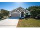 Charming single-story home with a well-manicured lawn and attached two-car garage on a sunny day at 19610 Sunset Bay Dr, Land O Lakes, FL 34638