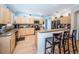 Bright kitchen with tile flooring and backsplash features an island with barstool seating at 19610 Sunset Bay Dr, Land O Lakes, FL 34638