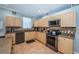 Well-equipped kitchen features wooden cabinetry, stainless steel appliances, and granite countertops at 19610 Sunset Bay Dr, Land O Lakes, FL 34638