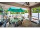 Screened patio features brick flooring, an umbrella-covered table, and access to the outdoors at 19610 Sunset Bay Dr, Land O Lakes, FL 34638