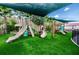 Community playground featuring slides, climbing structures, and palm trees, covered by a large sunshade at 19610 Sunset Bay Dr, Land O Lakes, FL 34638
