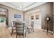 Elegant dining room featuring a tray ceiling, chandelier, neutral tones, and tile flooring at 2817 Cordoba Ranch Blvd, Lutz, FL 33559
