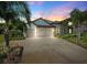 Beautifully landscaped two-story home featuring a three-car garage and stone accents, complemented by palm trees at 2817 Cordoba Ranch Blvd, Lutz, FL 33559
