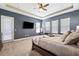 An expansive main bedroom with a large bed, plush carpet, a ceiling fan and a TV at 2817 Cordoba Ranch Blvd, Lutz, FL 33559