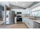 Stylish kitchen with white cabinets, stainless steel appliances, granite counters, and wood floors at 3039 Sean Way, Palm Harbor, FL 34684