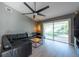 Bright living room with a black leather sectional and sliding glass doors to the backyard at 3039 Sean Way, Palm Harbor, FL 34684