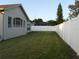 Side yard featuring green grass and a white vinyl fence providing backyard privacy at 30434 Colehaven Ct, Wesley Chapel, FL 33543