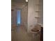 Bathroom featuring a tiled shower/tub, toilet with wood seat, and storage shelves at 30434 Colehaven Ct, Wesley Chapel, FL 33543