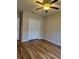Comfortable bedroom featuring light hardwood floors, a ceiling fan, and a spacious closet for storage at 30434 Colehaven Ct, Wesley Chapel, FL 33543