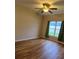 Comfortable bedroom features wood floors, neutral walls, ceiling fan, and bright window view at 30434 Colehaven Ct, Wesley Chapel, FL 33543