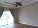 Bedroom with a ceiling fan, sliding door to backyard, and hardwood floors at 30434 Colehaven Ct, Wesley Chapel, FL 33543