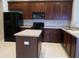 Kitchen with dark cabinets, stainless steel appliances, and an island prep area at 30434 Colehaven Ct, Wesley Chapel, FL 33543