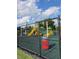 Community playground with slides and play equipment, fully enclosed with a secure fence for safety at 30434 Colehaven Ct, Wesley Chapel, FL 33543