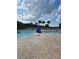 Community swimming pool with brick paver deck, lounge chairs, and palm trees at 30434 Colehaven Ct, Wesley Chapel, FL 33543