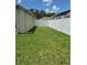 Grassy side yard enclosed by a white privacy fence, offering a secure and private space at 30434 Colehaven Ct, Wesley Chapel, FL 33543