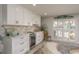 Charming bar area featuring white cabinets, a wine fridge, a marble countertop and plantation shutters with a view to the outdoors at 3235 Seaway Dr, New Port Richey, FL 34652
