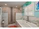 Stylish bathroom features a walk-in shower, soaking tub, and white vanity with double sinks at 3235 Seaway Dr, New Port Richey, FL 34652