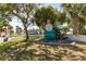 Charming private beach club entrance with inviting seating area, surrounded by lush greenery and palm trees at 3235 Seaway Dr, New Port Richey, FL 34652