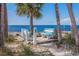 Relaxing beachfront benches under palm trees, offering a serene spot to enjoy picturesque ocean views at 3235 Seaway Dr, New Port Richey, FL 34652