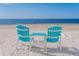 Inviting turquoise Adirondack chairs on sandy beach, perfect for relaxing and enjoying scenic ocean views at 3235 Seaway Dr, New Port Richey, FL 34652
