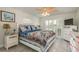 Cozy bedroom with coastal decor, ceiling fan, plantation shutters, and light wood-look flooring at 3235 Seaway Dr, New Port Richey, FL 34652