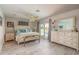 Serene main bedroom with ensuite bathroom access, light wood-look floors, and a ceiling fan at 3235 Seaway Dr, New Port Richey, FL 34652