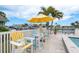 Outdoor patio chairs under an umbrella offer canal views from the pool at 3235 Seaway Dr, New Port Richey, FL 34652